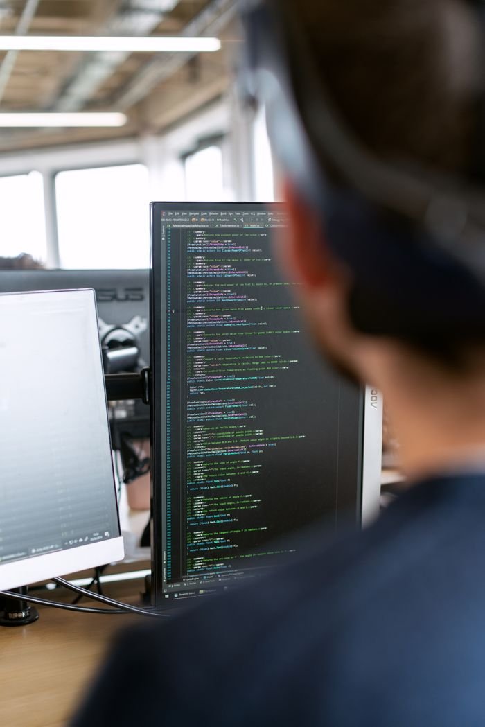 The Art of Drawing Readers In: Your attractive post title goes here A male software engineer working on code in a modern office setting.